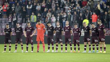 Hearts players stand wearing black armbands before the second half following the announcement of the death of Queen Elizabeth II, during the Europa Conference League Group A soccer match between Heart of Midlothian and Istanbul Basaksehir at Tynecastle Park, Edinburgh, Thursday, Sept. 8, 2022. (Robert Perry/PA via AP)