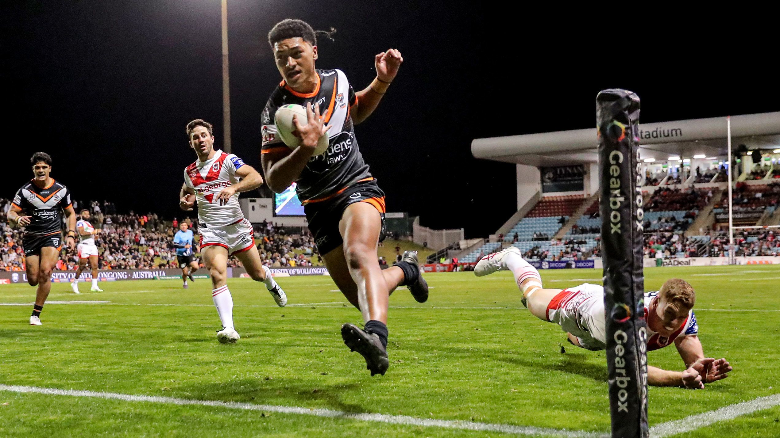 Junior Tupou of the Tigers runs in to score a try against the Dragons.