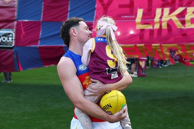 MELBOURNE, AUSTRALIA - APRIL 19: Lachie Neale of the Lions takes to the field with his daughter, Piper, during his 300th match during the sixth round AFL match between Melbourne Demons and Brisbane Lions at the Melbourne Cricket Ground, on April 19, 2026, in Melbourne, Australia. (Photo by Daniel Pockett/AFL Photos/via Getty Images)