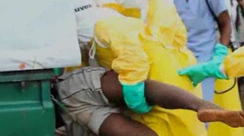 Doctors wrestle the Ebola patient into a 4WD ambulance. (Reuters)