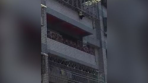 The child was stuck for around 30 minutes before men were seen abseiling down the outside of the building to rescue him. Picture: Taiwan Fun 666 via Storyful.