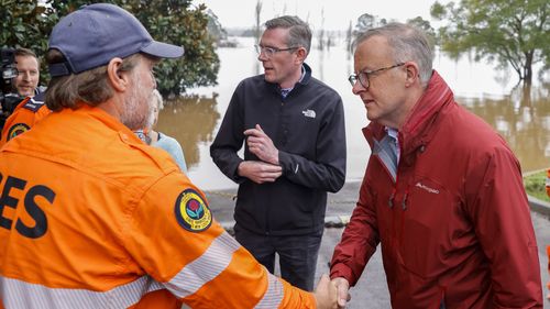 Prime Minister Anthony Albanese shakes hands with State Emergency Service workers on a tour of flood-affected areas with New South Wales Premier Dominic Perrottet in the suburb of Richmond, Sydney.