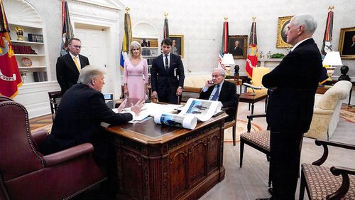 Donald Trump in one of his 18 interviews with Bob Woodward. On the president's desk are large photos of Mr Trump and Kim Jong-un.