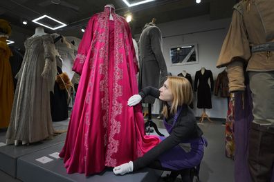 A costume handler adjusts Madonna's pink satin evening coat worn as Eva Peron, for the 1996 film Evita