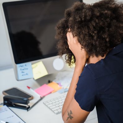 Stock photo: woman at work looks sad at her desk.