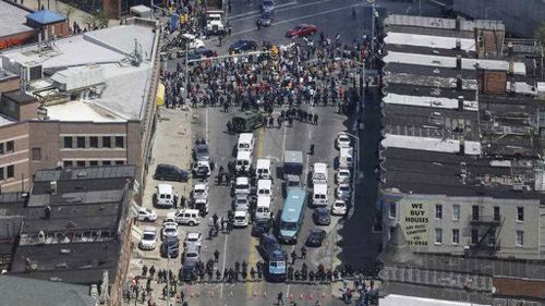 In this aerial photo, police stand in formation near a gathering of protesters at the intersection of North Avenue and Pennsylvania Avenue in Baltimore. (AP)