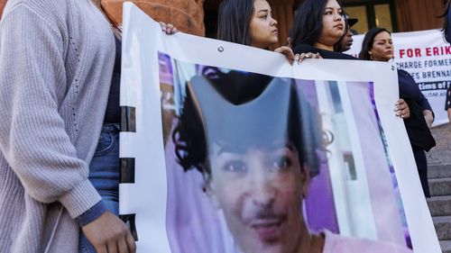 Daleen Garcia, front left, and two of Eric Cantu's siblings hold a banner featuring a picture of him during a press conference held to update the public about his current medical condition in front of the Bexar County Courthouse in San Antonio.