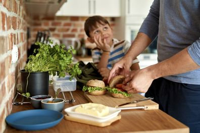 Father making lunch for son in kitchen. Dad making school lunches. Sandwich. 