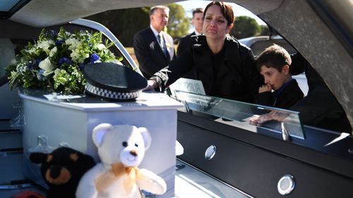 Senior Constable Brett Forte's wife, Senior Constable Susan Forte, touches her late husband's coffin. (AAP)