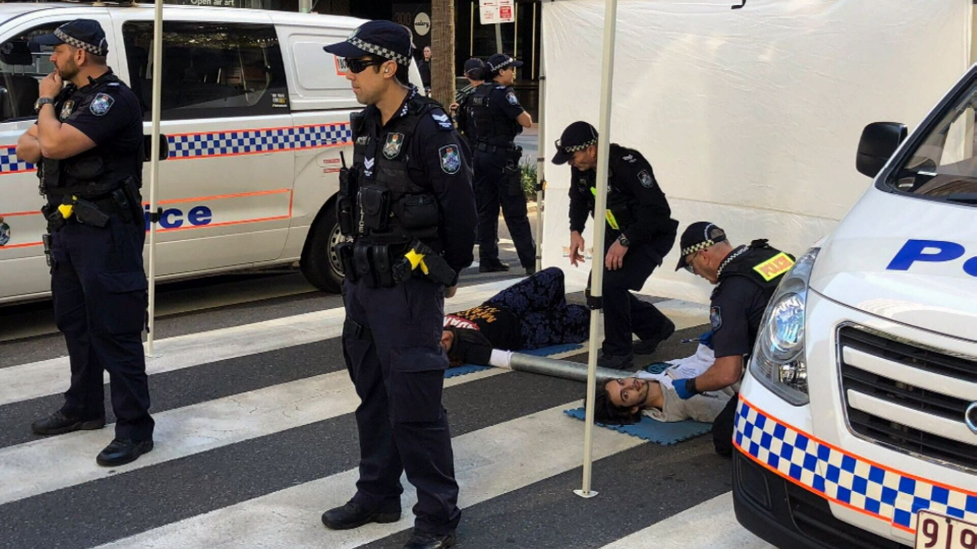 Climate protesters glue hands to road in Brisbane CBD