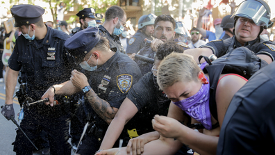 New York Police officers use pepper spray on protesters during a demonstration Saturday, May 30, 2020, in the Brooklyn borough of New York. Protests were held throughout the city over the death of George Floyd, a black man who was in police custody in Minneapolis. Floyd died after being restrained by Minneapolis police officers on Memorial Day. (AP Photo/Seth Wenig)