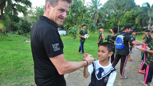 Peter Baines, pictured with Thai locals his charity has helped. 