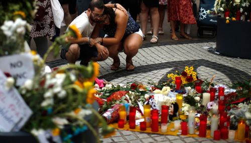 Mourners lay flowers and lit candles.