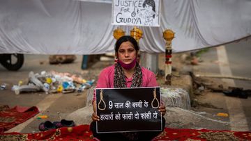 Tina Verma, 27, a social activist, holds a placard which reads, &quot;Hang the killers of 9-year old child&quot;.