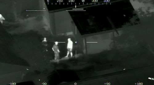 Police approach a man after helicopter cameras managed to locate him for aiming a laser beam at the aircraft. (A Current Affair)
