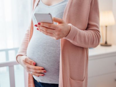 Pregnant woman holding belly.