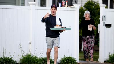 New Zealand Labour Party leader Jacinda Ardern's partner Clarke Gayford delivers home cooked food to the media waiting outside their house on October 17, 2020 in Auckland, New Zealand