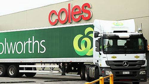 Woolworths truck outside Coles supermarket building in Melbourne (Getty)