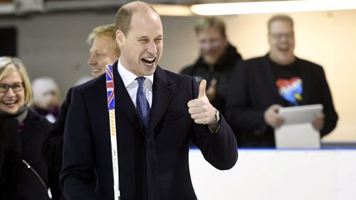 Prince William gives the thumbs up after shooting a puck during his encounter with the Icehearts on his visit to Finland. (AAP)