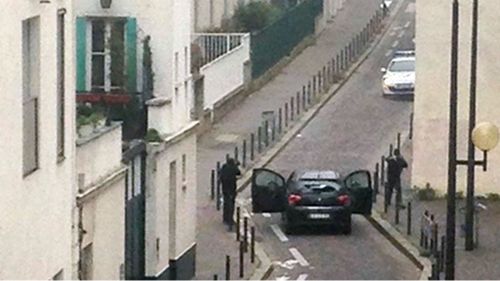 The gunmen face police officers near the offices of the Paris offices of satirical newspaper Charlie Hebdo. (Getty)