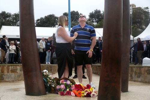 A man pauses and looks to the sky after laying a flower at the Bali memorial in Coogee.