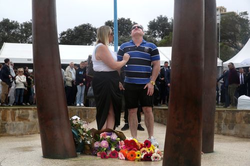 Un homme s'arrête et regarde vers le ciel après avoir déposé une fleur au mémorial de Bali à Coogee.