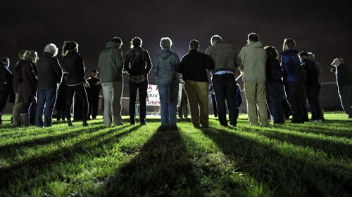 People form a circle and pray against the death penalty.