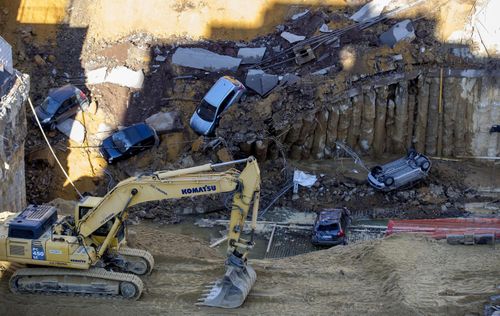 . A number of parked cars fell into the sinkhole, but no casualties were reported. (AP)
