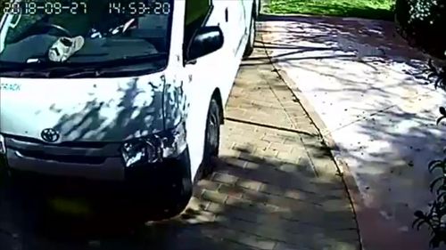 A delivery driver has been caught on camera letting his van roll into a garage door.