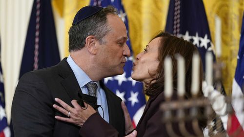 Vice President Kamala Harris and second gentleman Doug Emhoff kiss during an event in the East Room of the White House in Washington, to light the menorah to celebrate Hanukkah, Dec. 1, 2021.