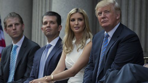Donald Trump, right, sits with his children, from left, Eric Trump, Donald Trump Jr. and Ivanka Trump during a ribbon-cutting ceremony at the Trump International Hotel in Washington, July 23, 2014. 