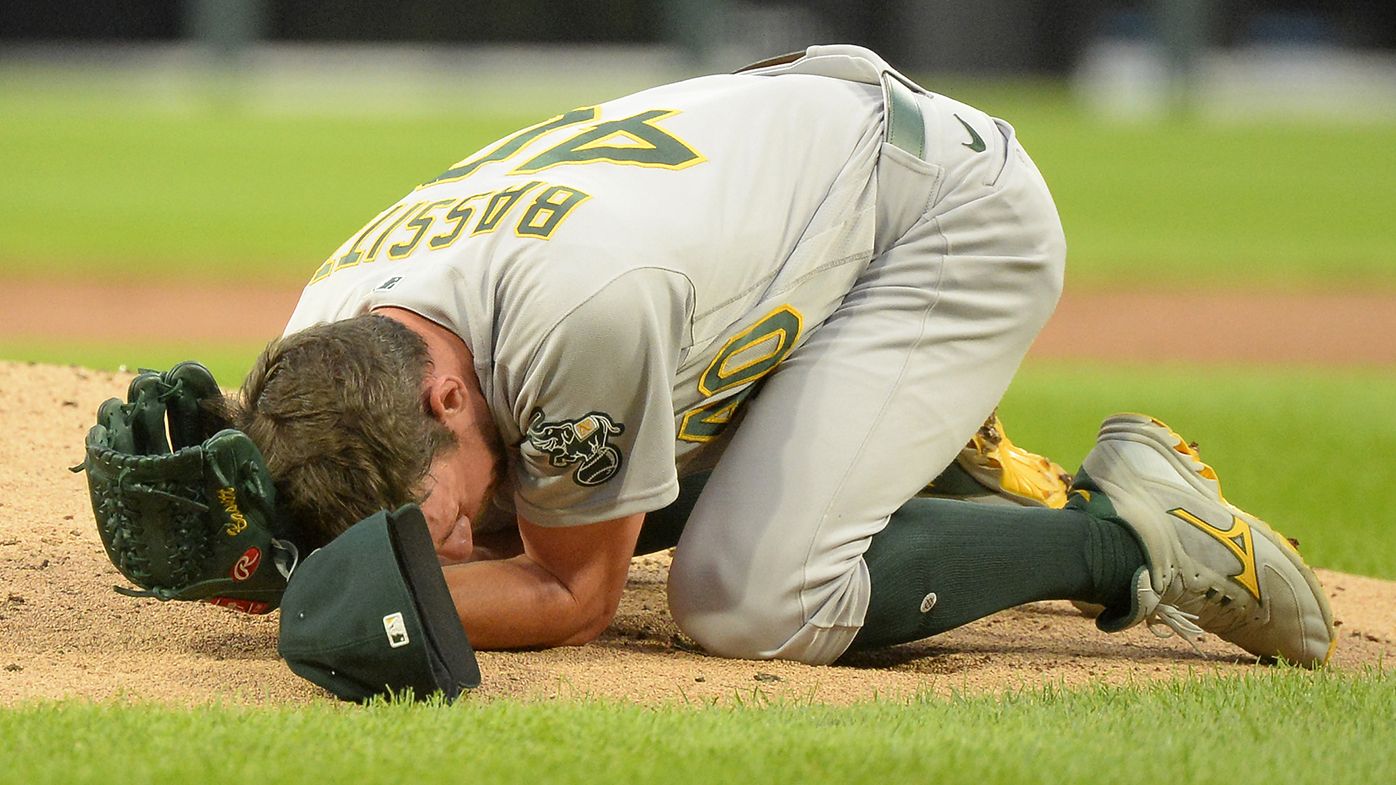 Chris Bassitt of the Oakland Athletics lies on the ground after being hit in the face by a line drive in the second inning off the bat of Brian Goodwin of the Chicago White Sox.