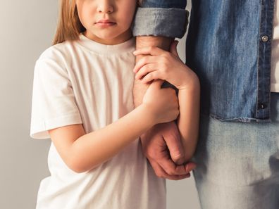 Young girl holds father's arm