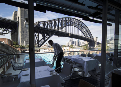 Iain Wood, assistant manager at Aqua Dining, sets tables before opening to guests on May 16, 2020 in Sydney, Australia.