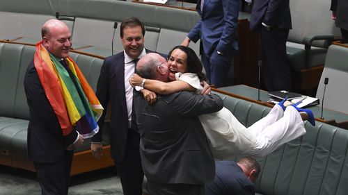  Liberal MP Warren Entsch lifts up Labor MP Linda Burney as they celebrate the passing of the bill. (AAP)
