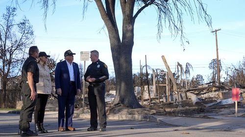 President Donald Trump and first lady Melania Trump walk with Jason Hing, chief deputy of emergency services at the Los Angles Fire Department, left, and Capt. Jeff Brown, chief of Station 69, as they tour the Pacific Palisades neighborhood affected by recent wildfires in Los Angeles, Friday, Jan. 24, 2025. (AP Photo/Mark Schiefelbein)