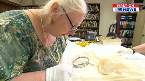 Costume historian Kay Inverarity inspected Mr Pike's royal find. (9NEWS)