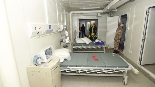 A Chinese army medic looks at a patient room at the Huoshenshan temporary field hospital. 