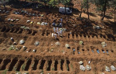 Cemetery workers in protective clothing bury a person who died of COVID-19, at the Vila Formosa cemetery in Sao Paulo, Brazil.