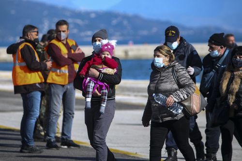 Passengers arrive at the port of Corfu island, northwestern Greece, after being evacuated from a ferry, Friday, Feb. 18, 2022