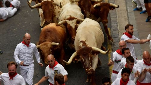 Revellers run next to fighting bulls during the running of the bulls at the San Fermin Festival, in Pamplona, northern Spain, in 2019. It was the last time the annual event was held in Pamplona due to the pandemic.