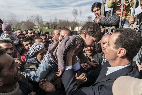 He is seen embracing and kissing children. (AAP)