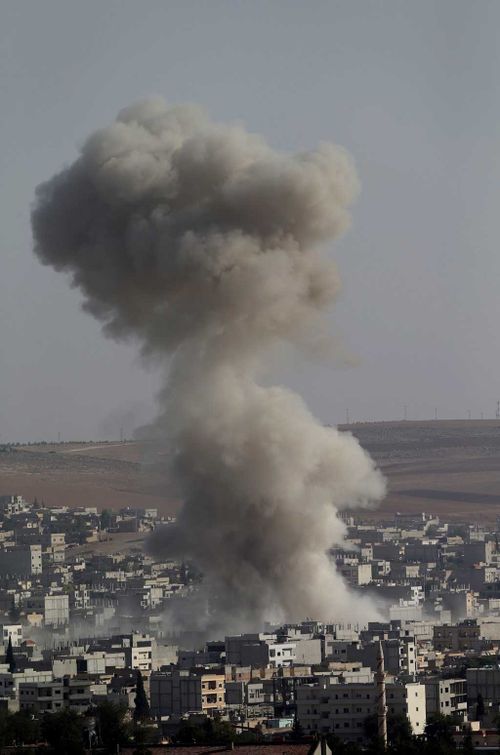 A view from Turkish territory showing smoke rising in Kobane after an airstrike by allegedly allianz war plane during armed clashes between ISIL and Kurdish fighters YPG who are trying to defend Kobane. (AAP)