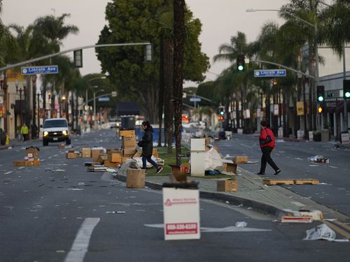 Residents walk across a Lunar New Year festival site after it was canceled due to a mass shooting nearby in Monterey Park, California.