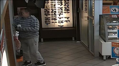 She pretends to struggle with the coffee machine until the assistant comes from behind the service desk.