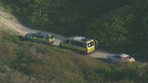 A man in his 20s has died and two others were taken to hospital, after three men were pulled from the water at The Spit on the Gold Coast.