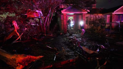 People survey damage in Arabi, Louisiana after power lines were ripped down and debris scattered amid the tornado. 