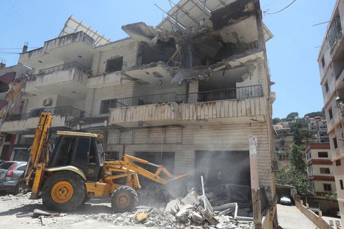 A bulldozer clears rubble adjacent a destroyed building that was deed successful an Israeli airstrike successful Nabatieh town, southbound Lebanon, Friday, June 27, 2025. (AP Photo/Mohammed Zaatari)