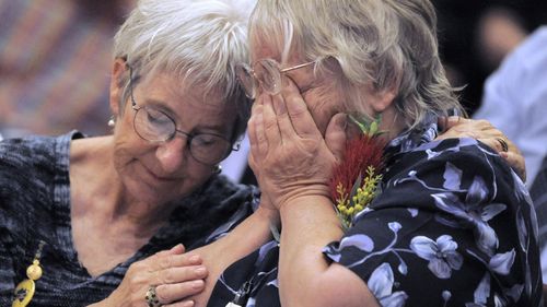 Two women comfort each other as they attend a ceremony in the Australian capital of Canberra, Monday, Nov. 16, 2009, where Australian Prime Minister Kevin Rudd issued an apology to thousands of impoverished British children shipped to Australia 