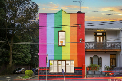 Exterior of home features the pride flag and a Freddie Mercury mural